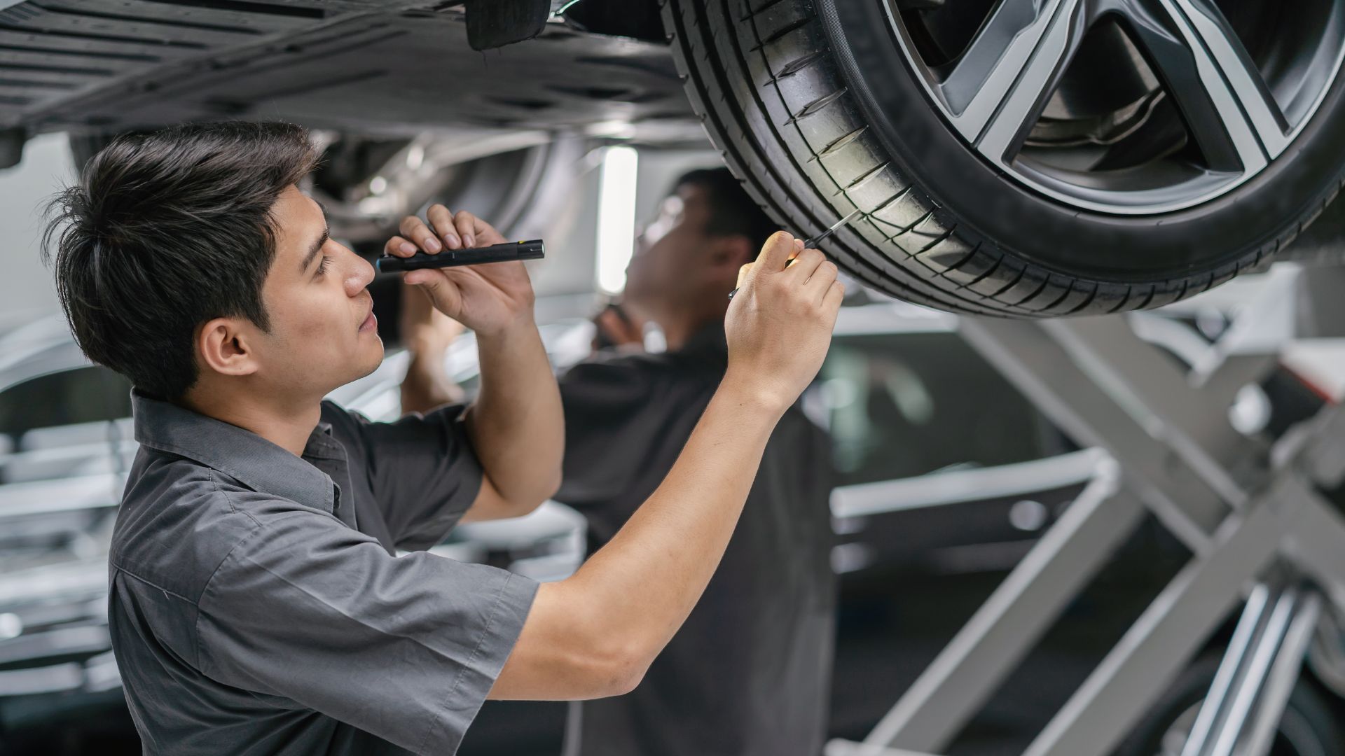 a man working on a car in a garage.