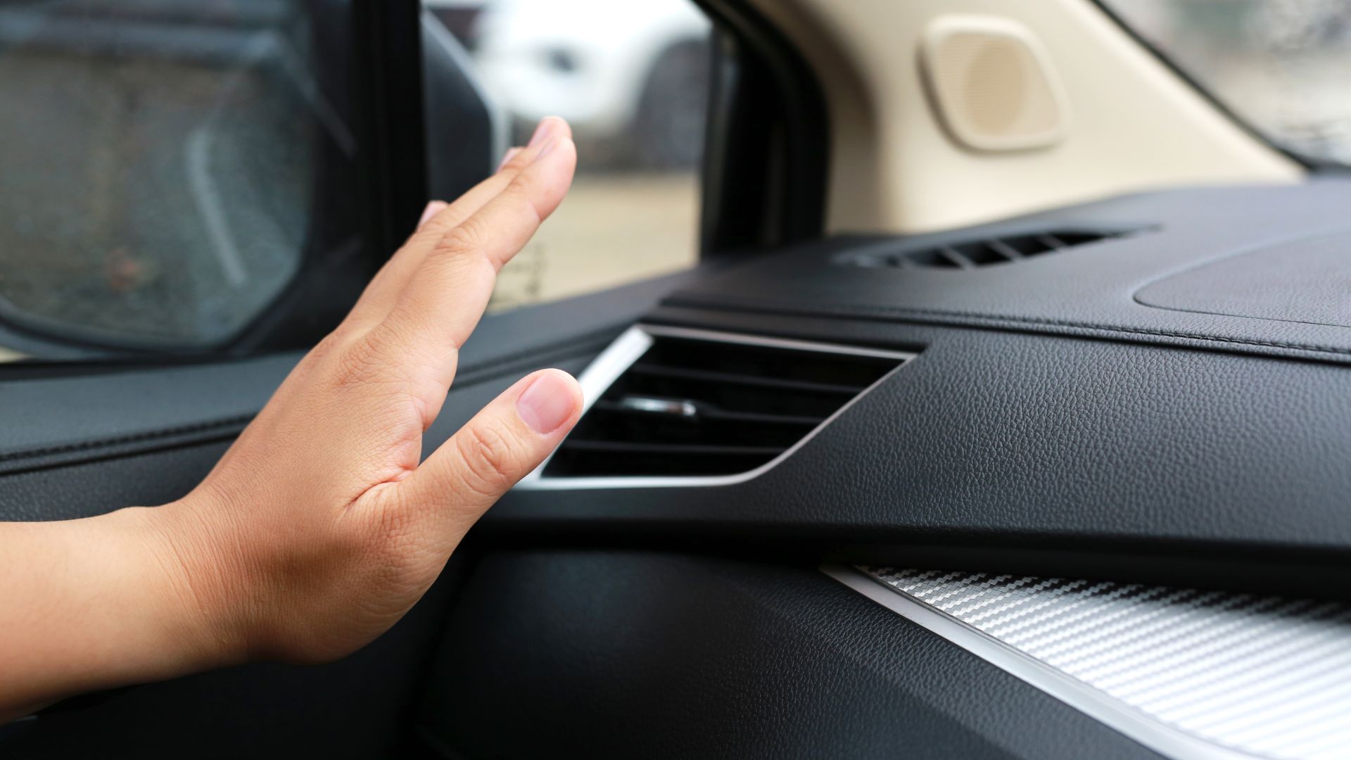 a hand on the dashboard of a car.