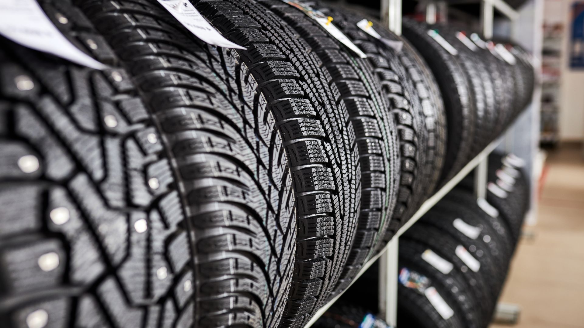 New tires displayed on racks in a tire shop.