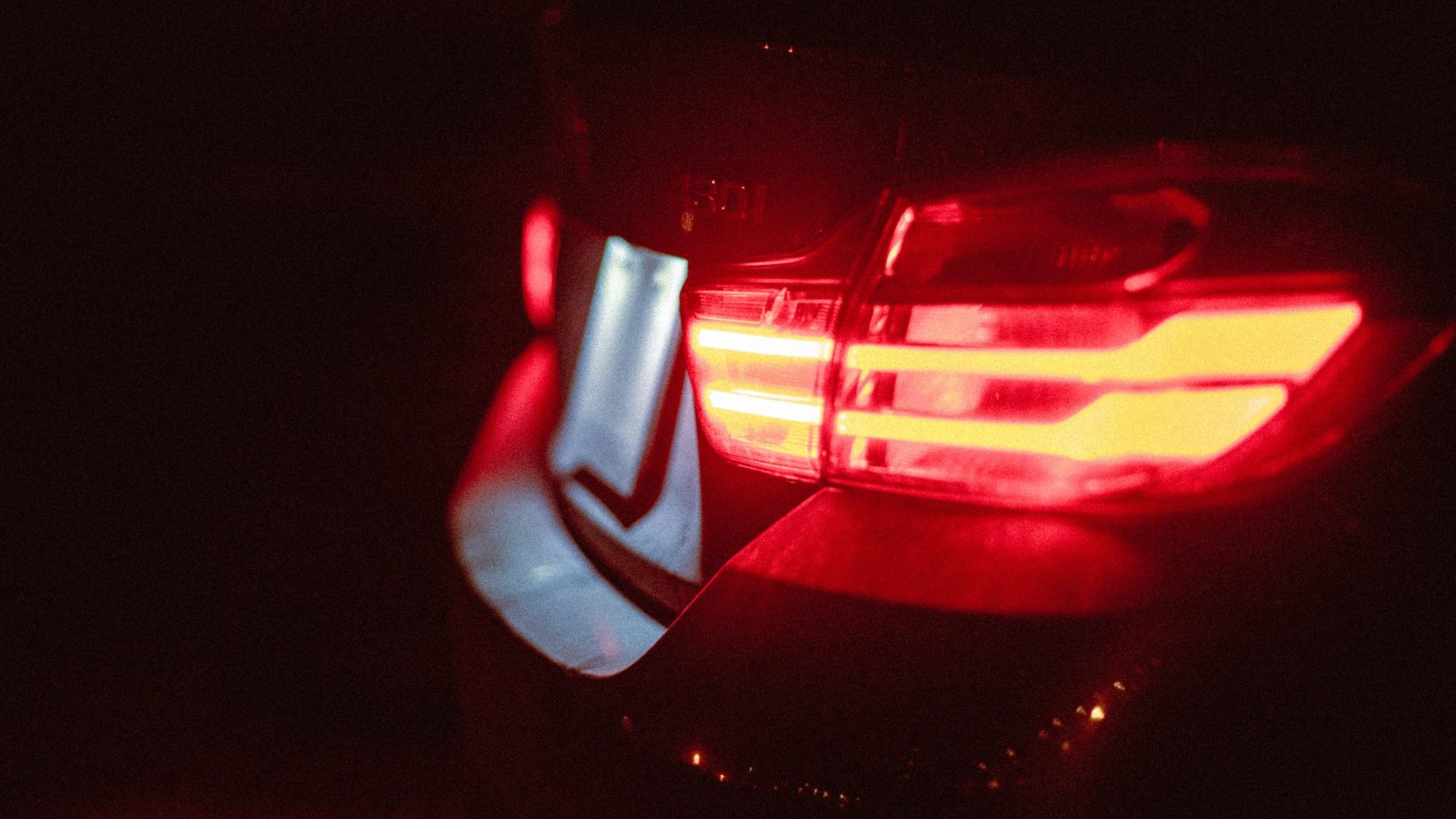 the tail light of a car in the dark.