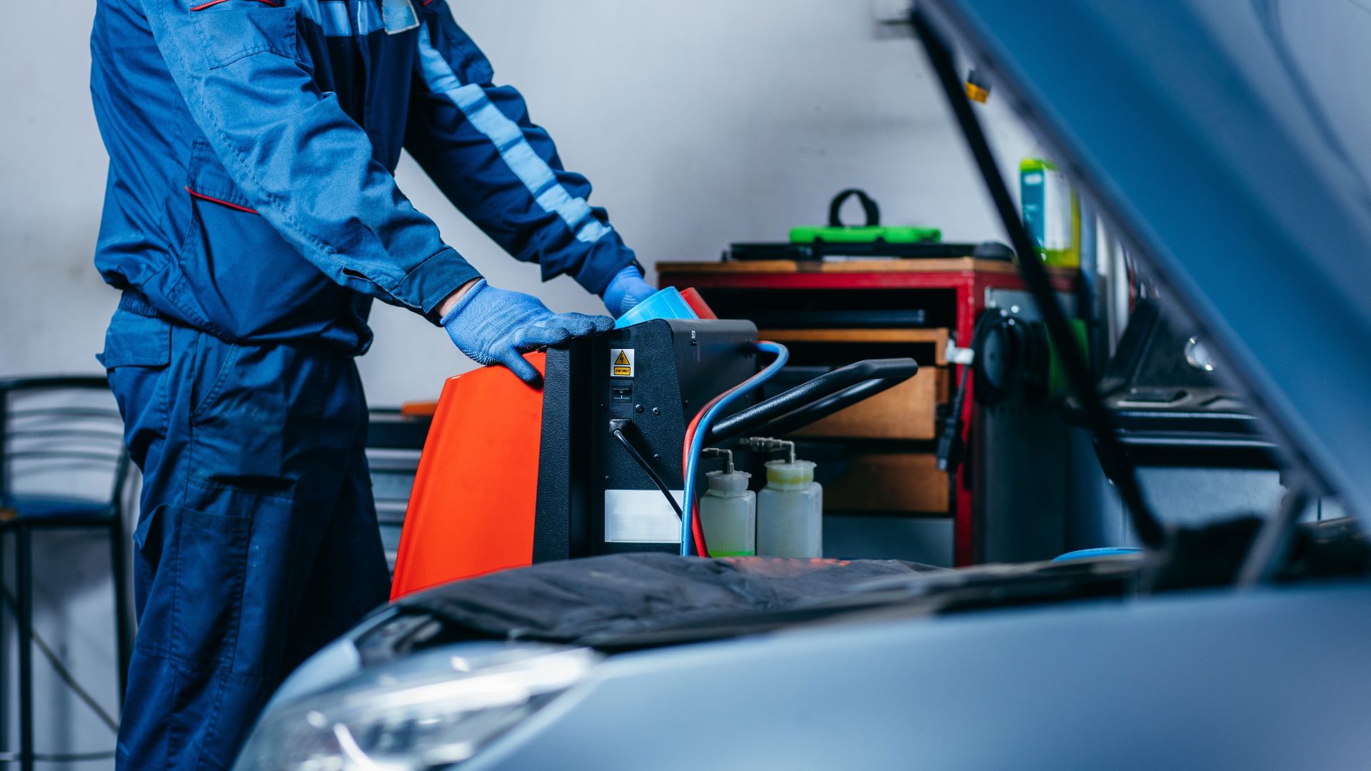 a man working on a car in a garage.