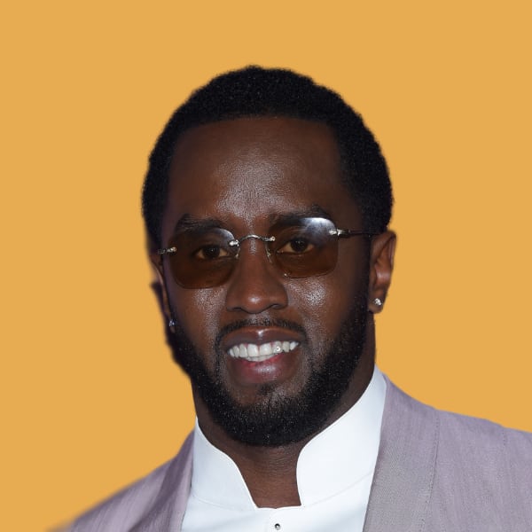 a man in a suit and tie wearing sunglasses.|a white and black car is on display at a car show.