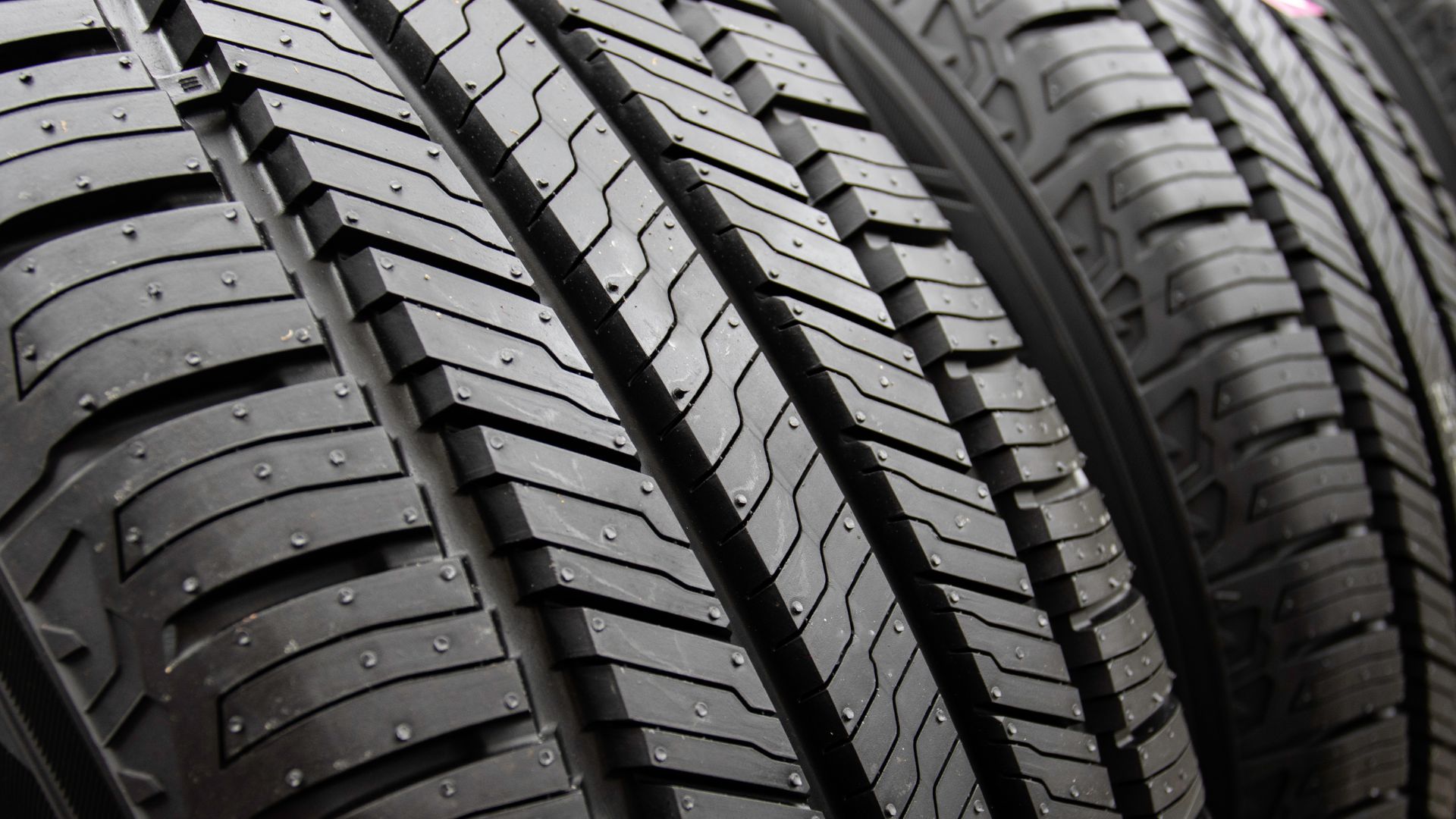 a row of tires sitting next to each other.|a close up of a tire on a car.