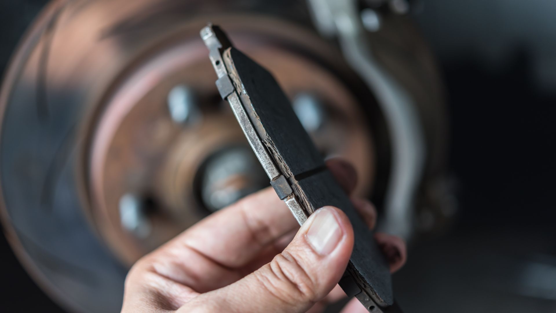 a man working on a brake assembly on a car.