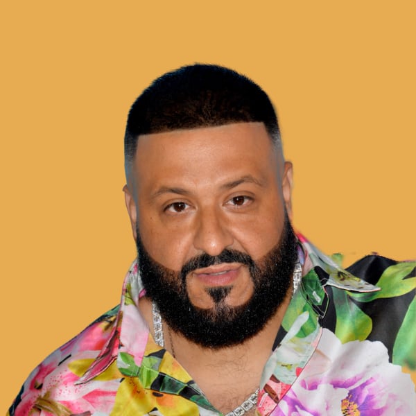a man with a beard wearing a flower shirt.|a white suv parked in a field with mountains in the background.