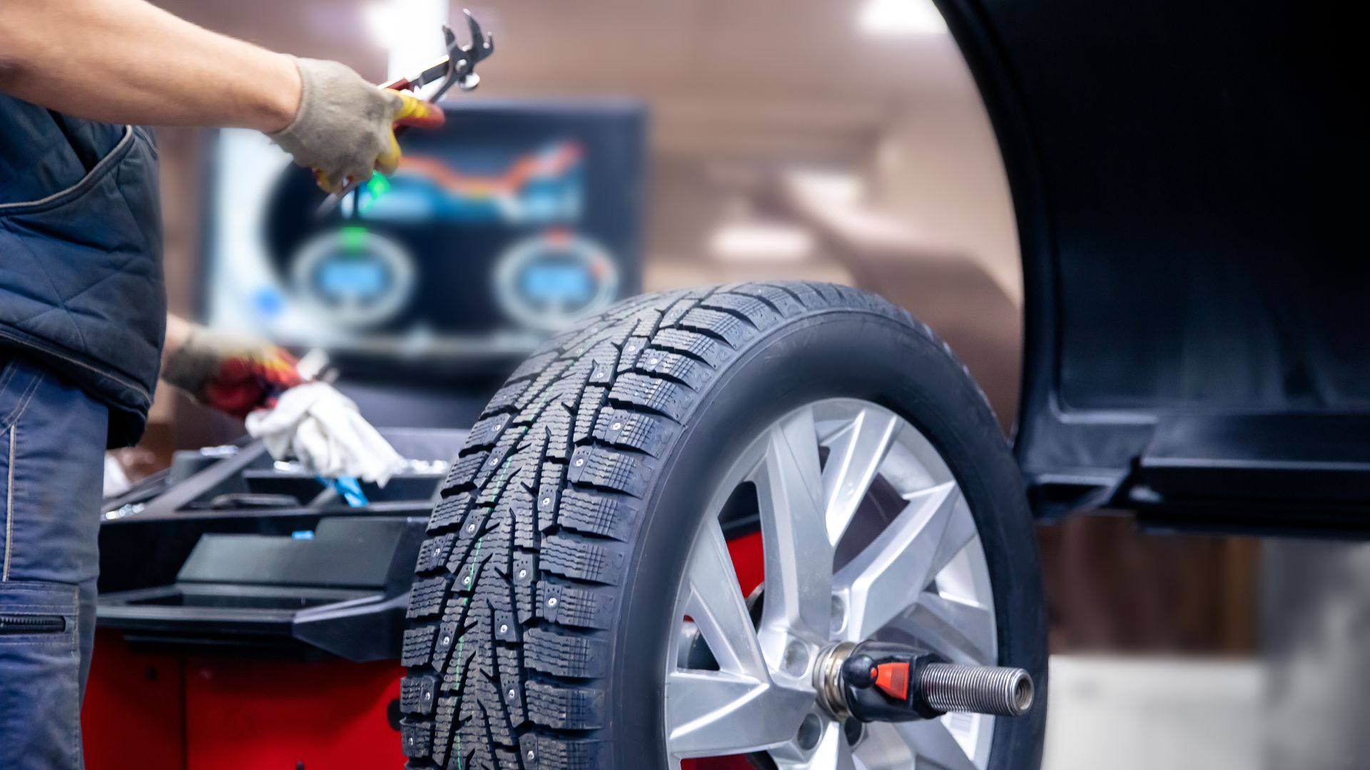 a man working on a tire on a car.
