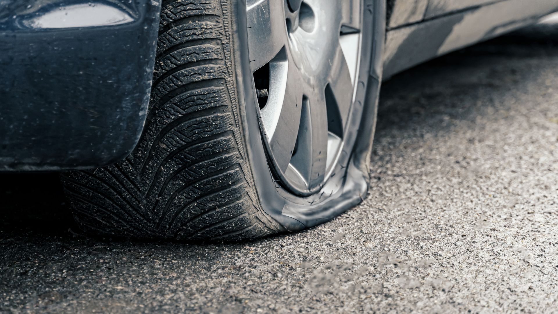 a close up of a tire on a car.|a person changing the tire of a car.