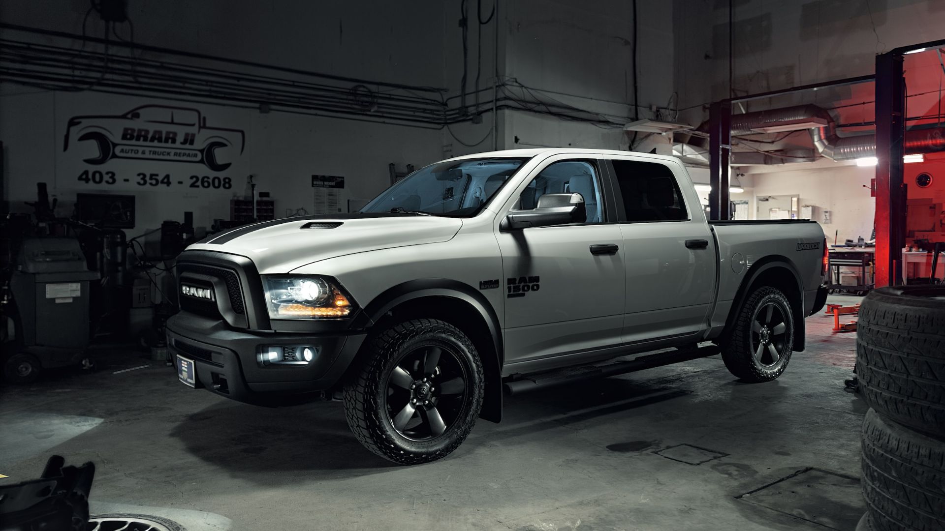 a white truck parked in a garage next to some tires.