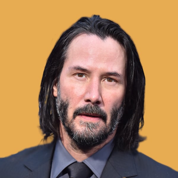 a man with long hair wearing a suit and tie.