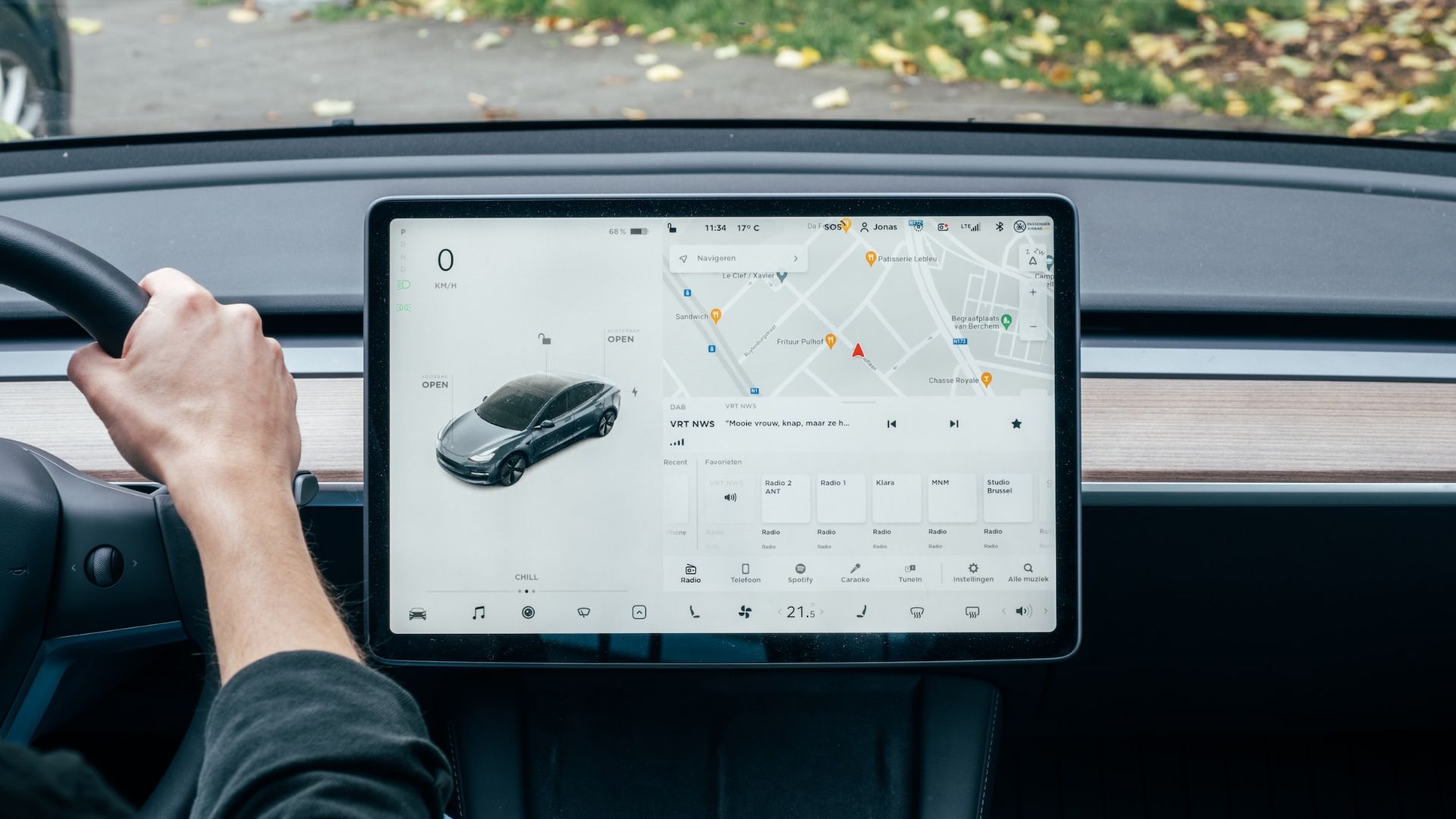 a person driving a car with a computer on the dashboard.