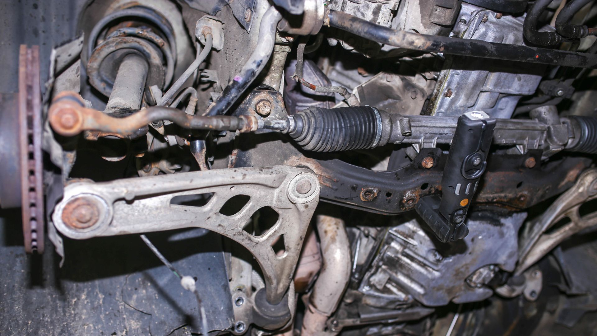 a close up of a metal object with a wrench.|a machine that is sitting on a table.|a person pouring a liquid into a car engine.