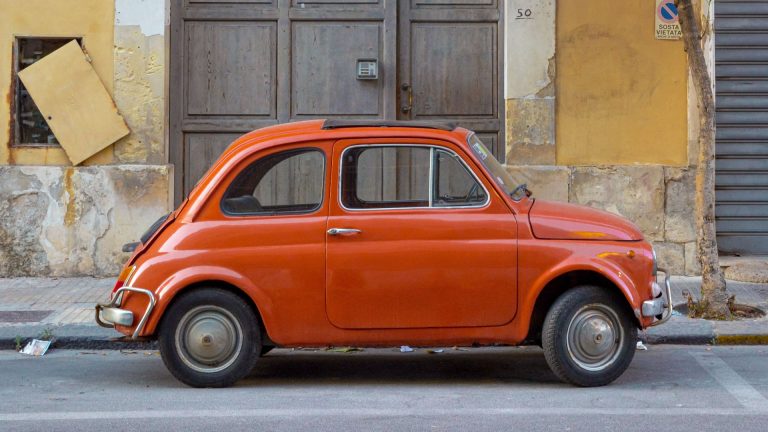 an orange car parked on the side of the road.