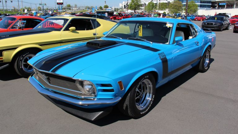 a blue muscle car parked in a parking lot.