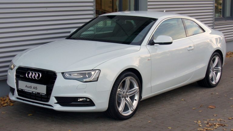 a white car parked in front of a building.