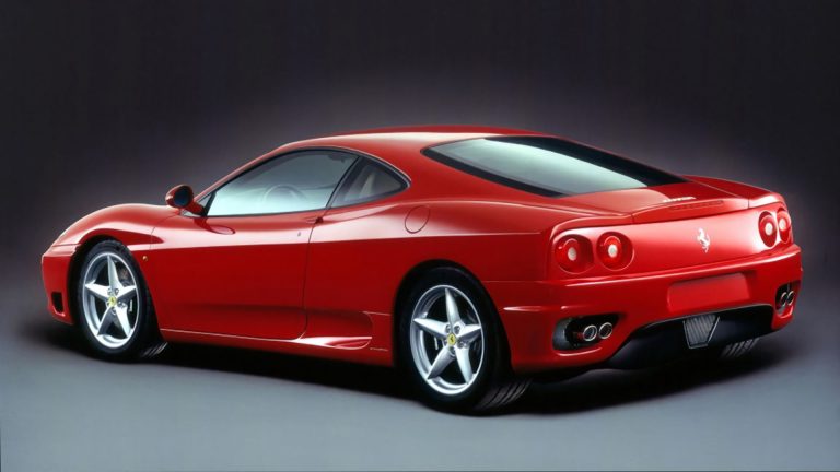 a red sports car parked in a studio.