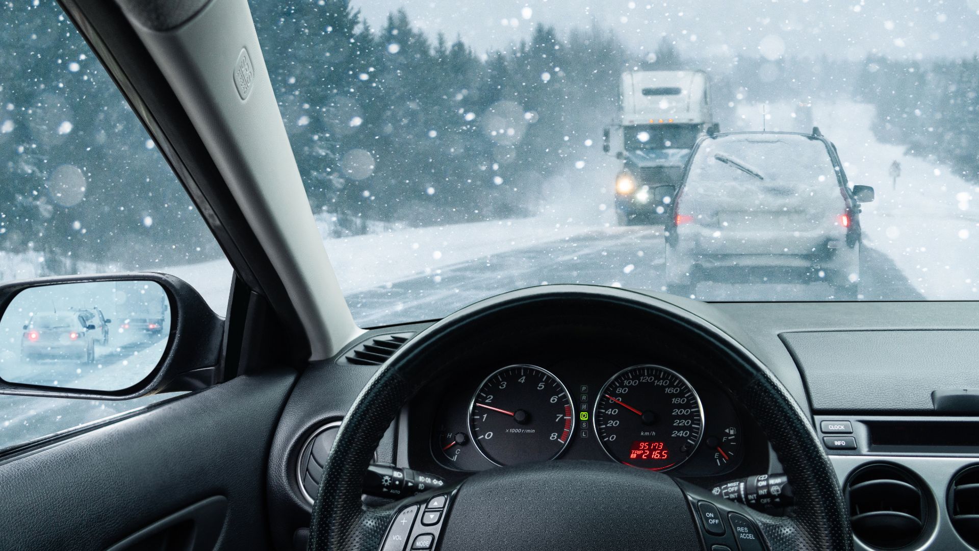 a car driving down a snow covered road.