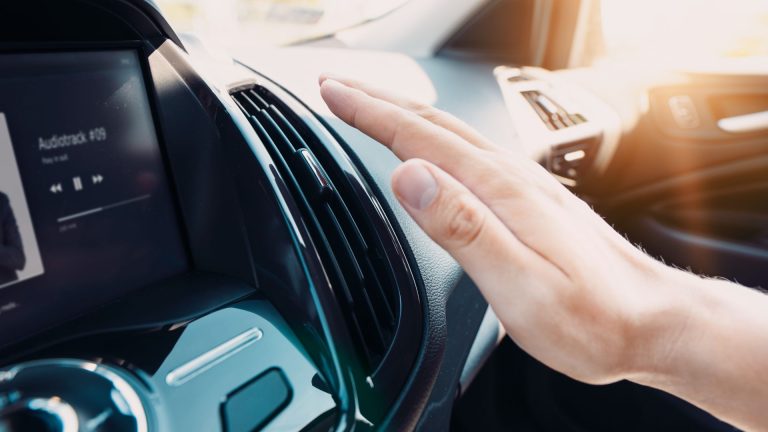 a hand on the dashboard of a car.