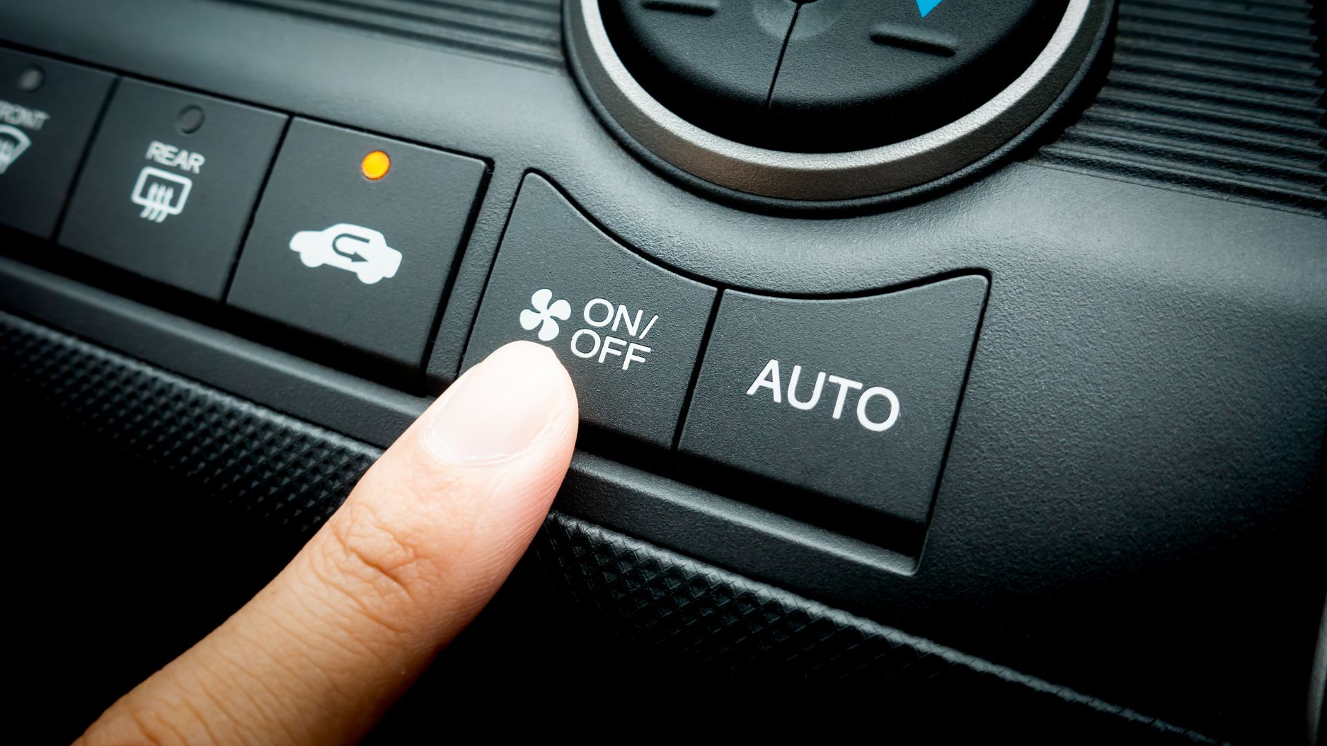 a person pressing a button on a car radio.