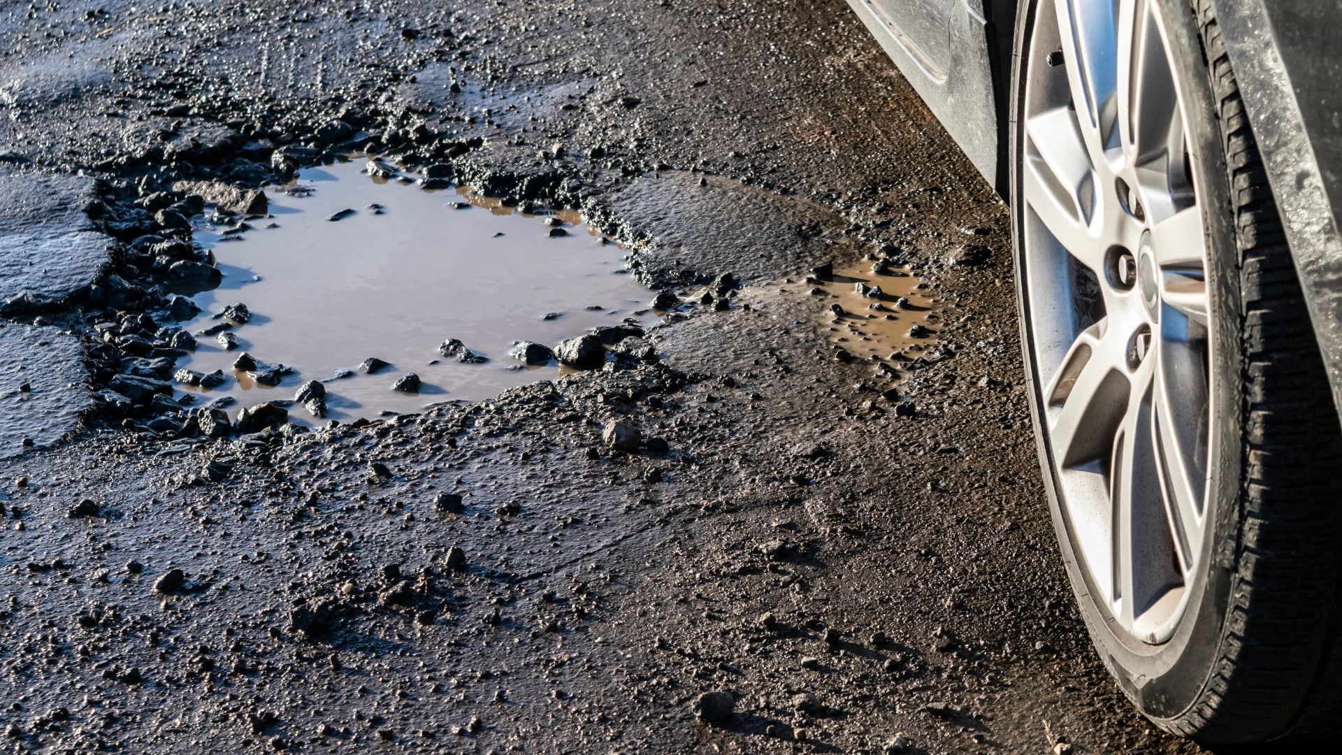 a puddle of water next to a car tire.