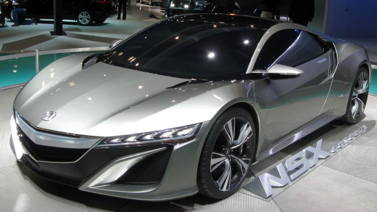 a silver sports car on display at a car show.