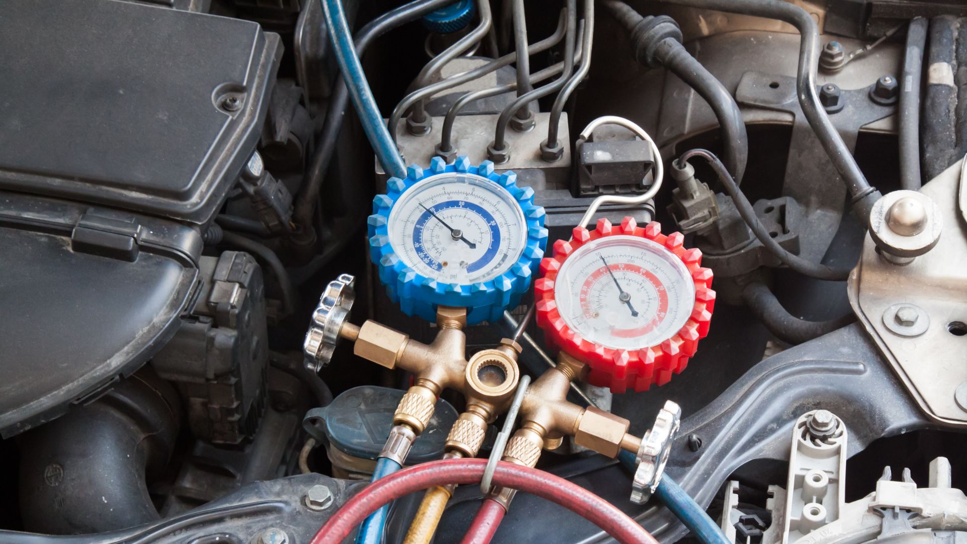 a couple of gauges sitting on top of a car engine.