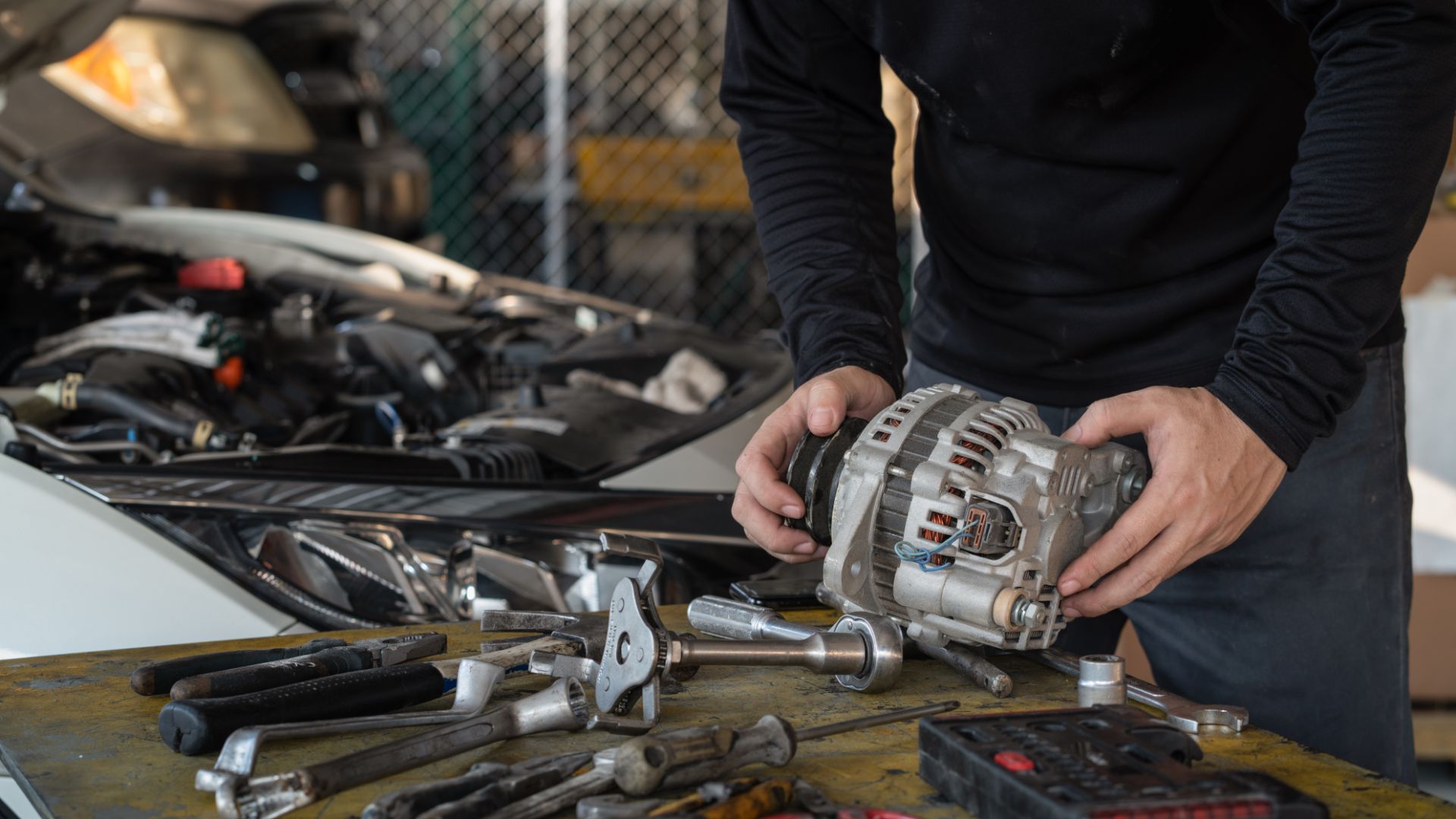 a man working on an engine in a garage.