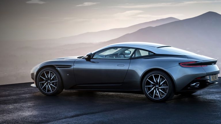 a grey sports car parked on top of a mountain.