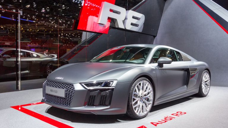 a silver car is on display at a show.