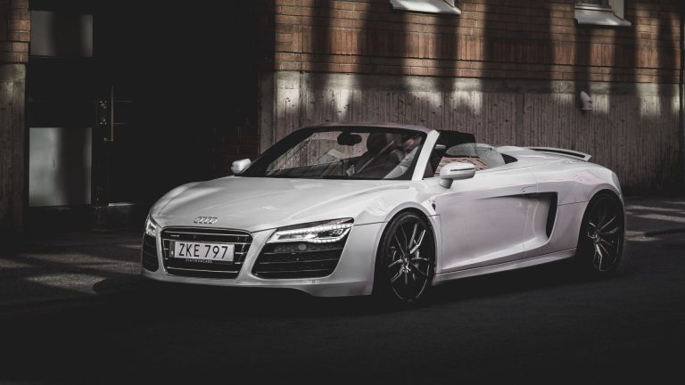 a white sports car parked in front of a building.