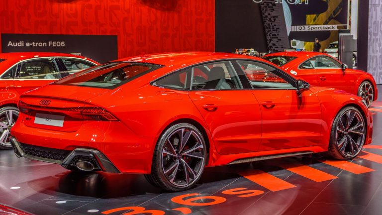 a red car is on display in a showroom.