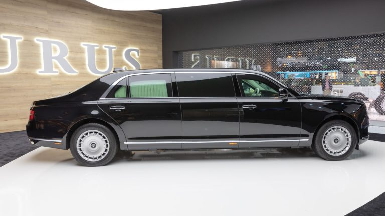 a black car is on display in a showroom.