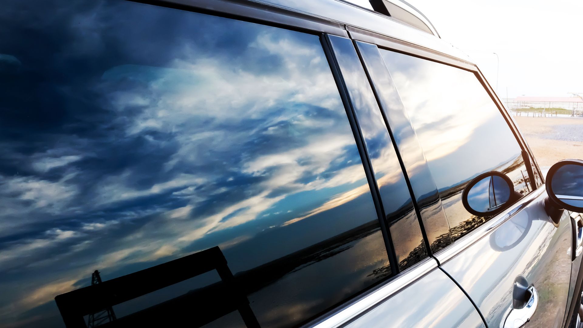 a reflection of the sky in the side mirror of a car.