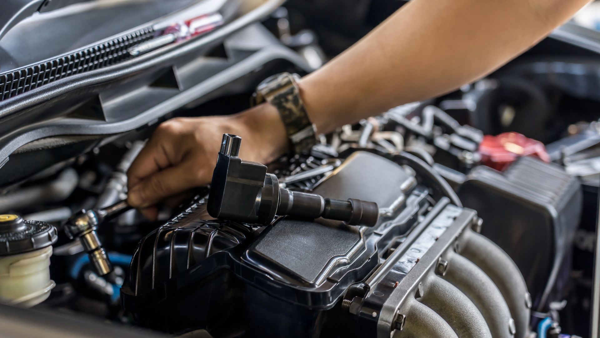 a close up of a person working on a car engine.