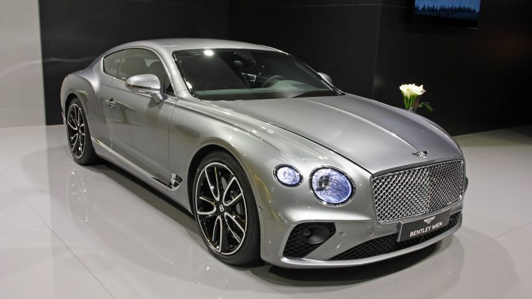 a silver sports car on display at a show.