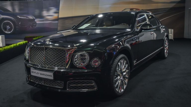 a black car is on display at a show.