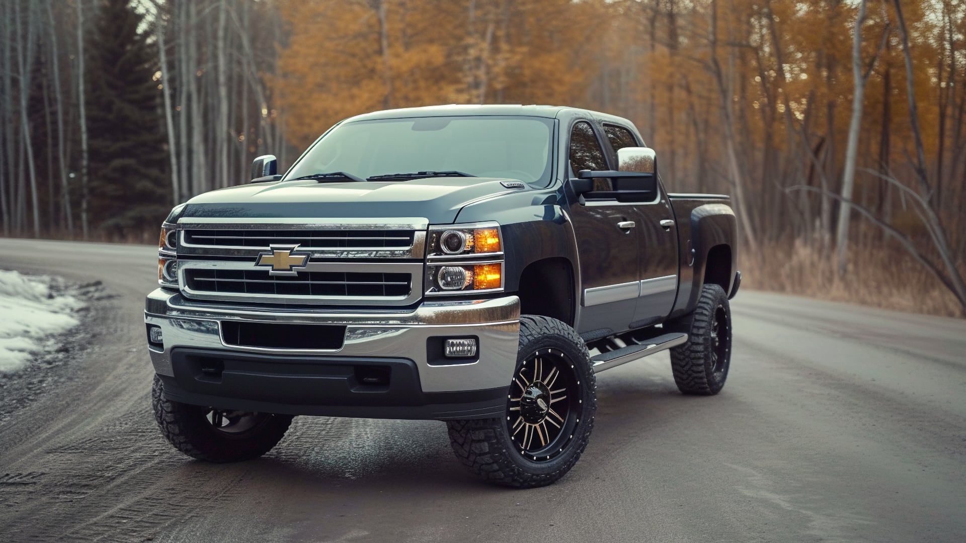 A black Chevrolet Silverado, one of the years to avoid, is driving down a dirt road.