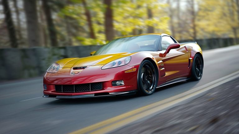 A red sports car cruising down the road.