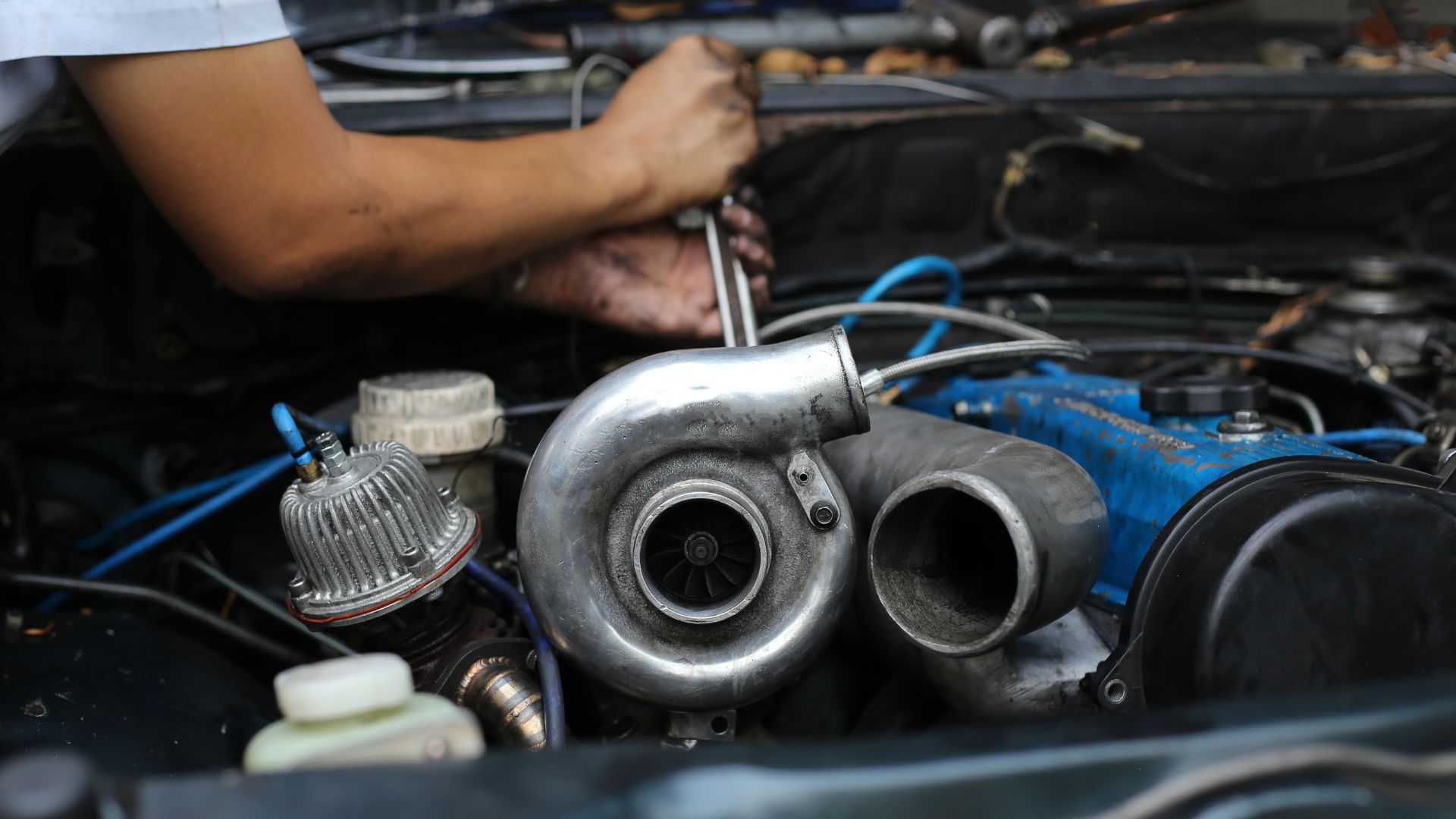 a close up of a person working on a car engine.