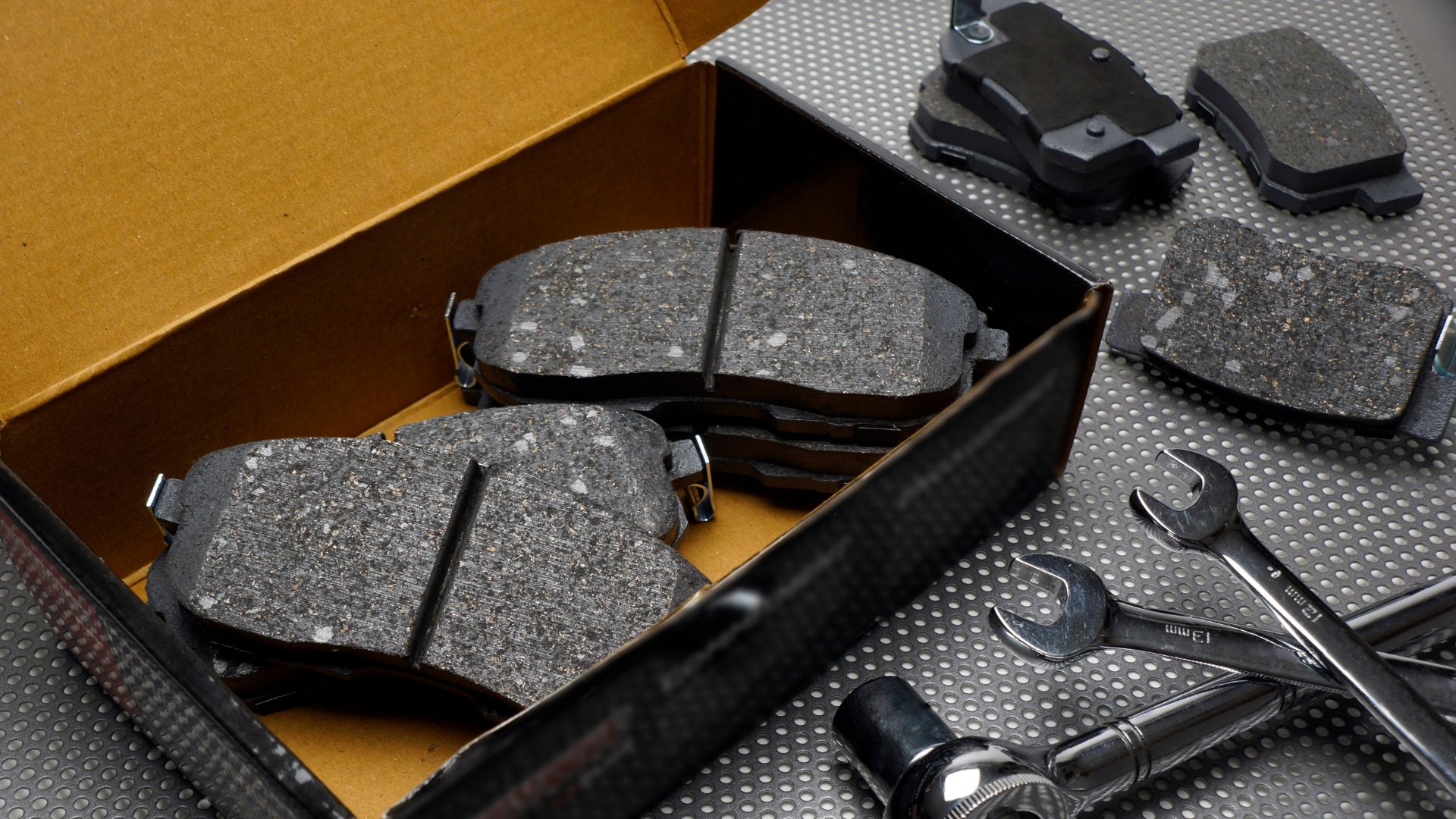 a box of brake pads and tools on a table.