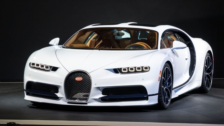 a white bugatti is on display at a car show.