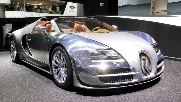 a silver bugatti is on display at a car show.