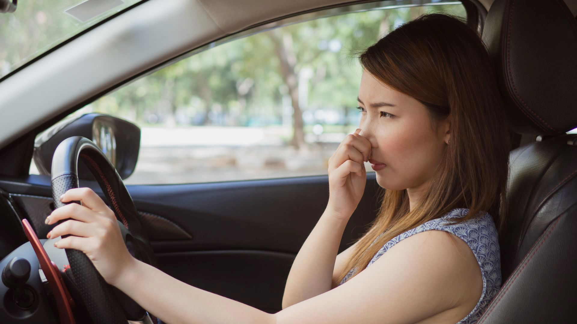 a woman sitting in a car talking on a cell phone.