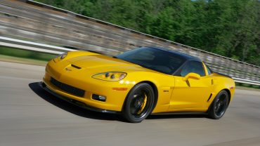 a yellow sports car driving down a road.