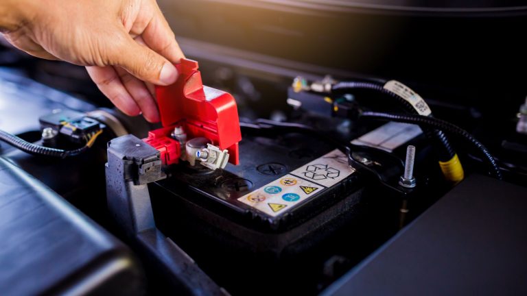 a person is working on a car battery.