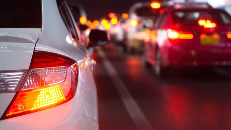 a close up of a car's tail lights on a city street.