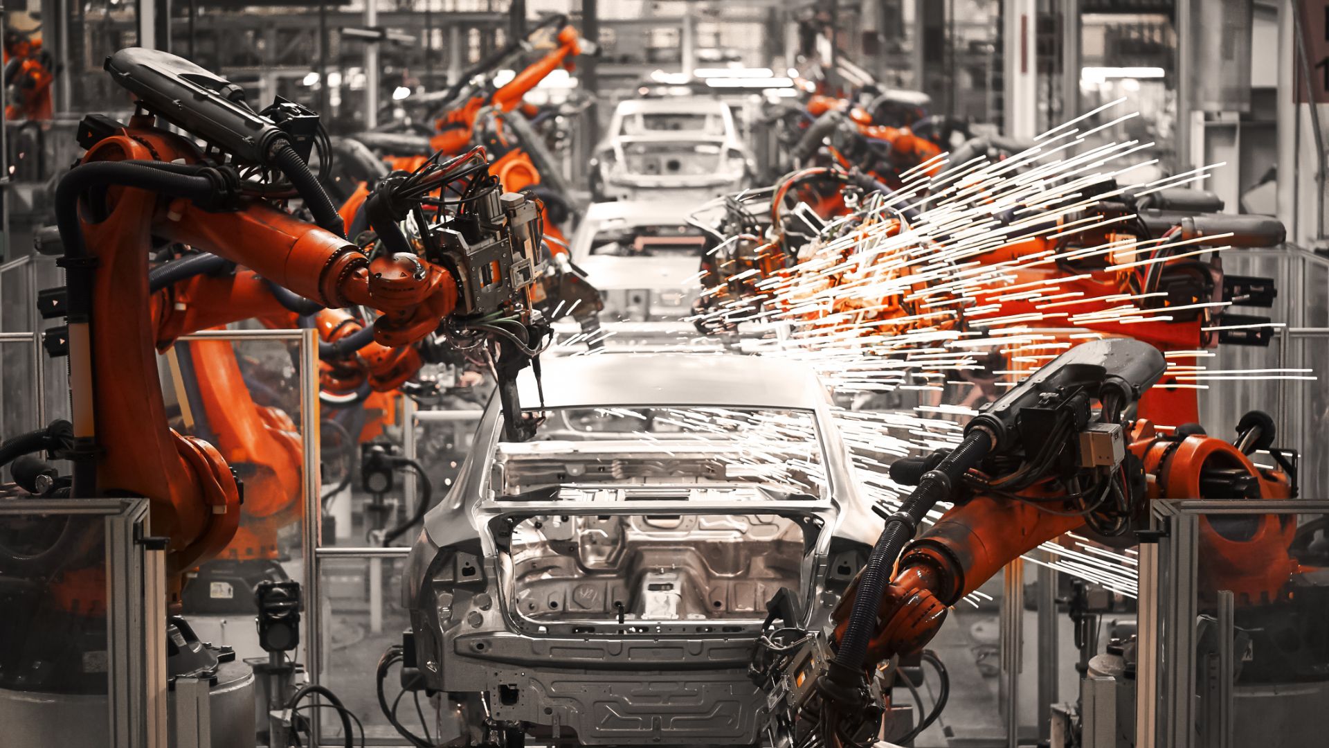 an assembly line with robots working on cars.