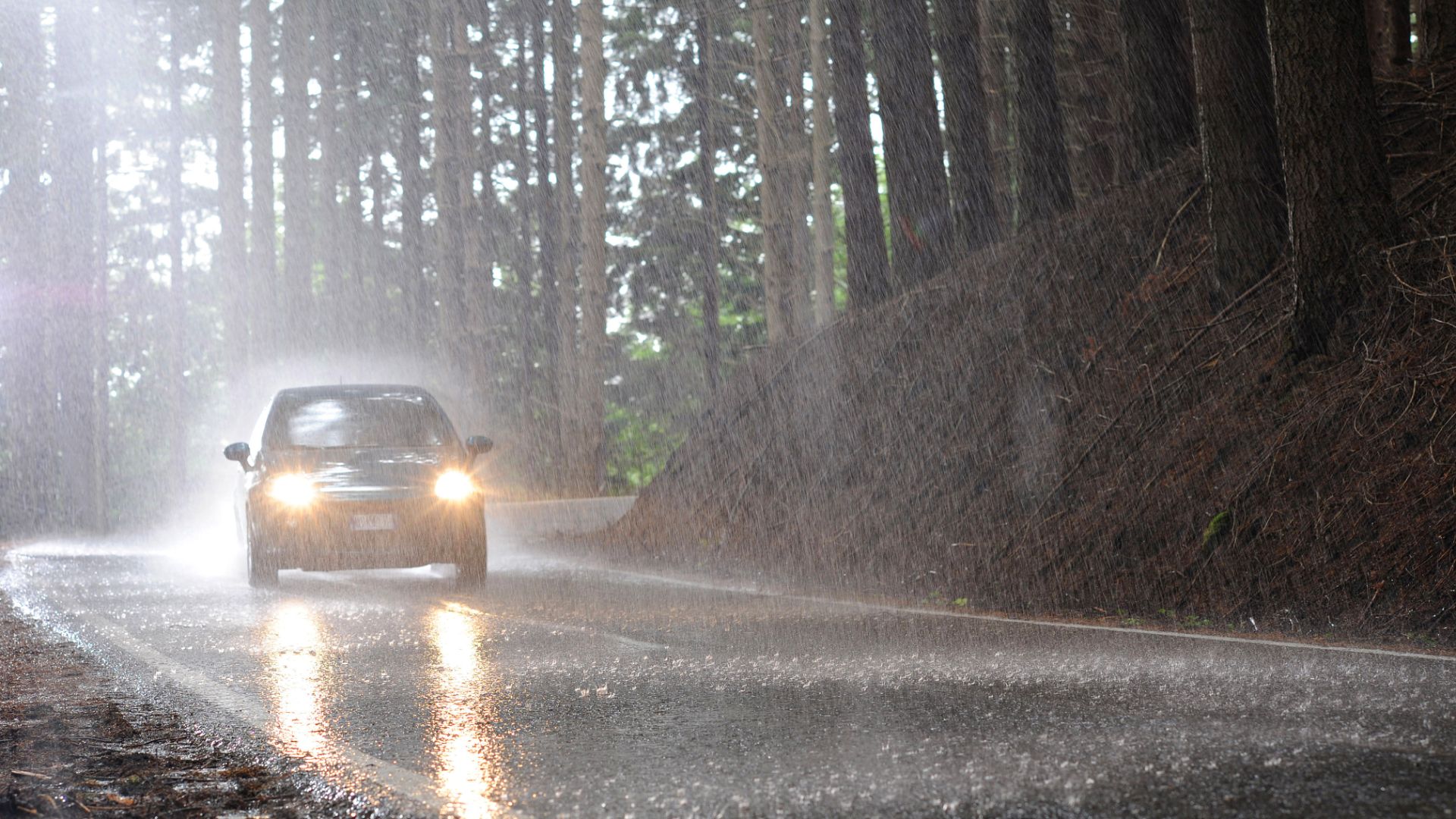 a car driving down a wet road in the rain.