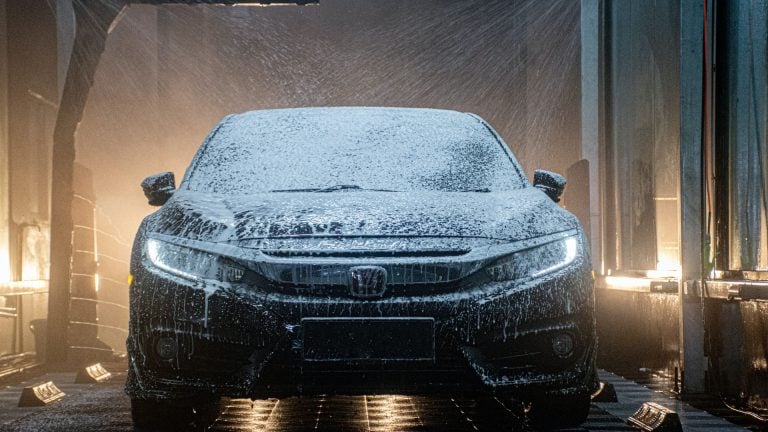 a car is covered in snow in a garage.