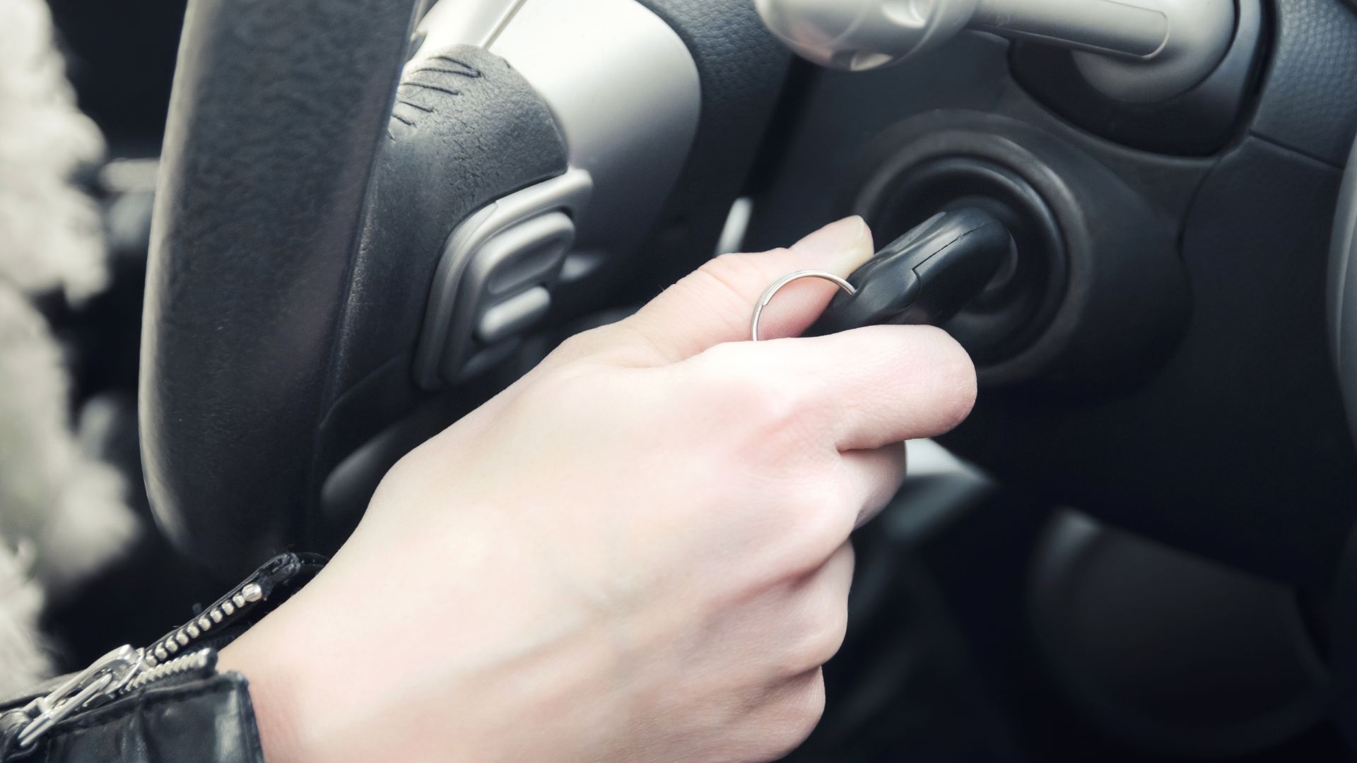 a person holding a cell phone while driving a car.