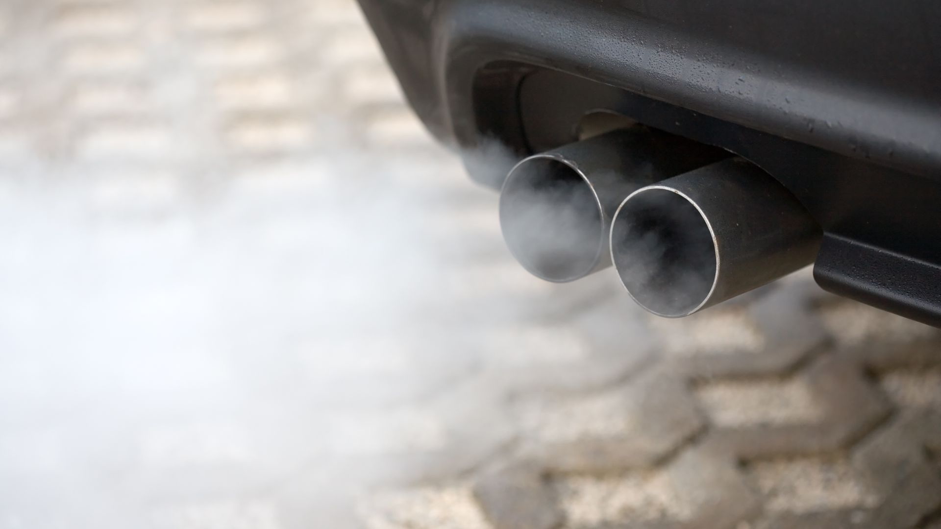 a close up of smoke coming out of a car's exhaust system.